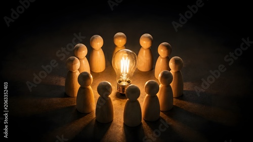 Team of Wooden Figures Gathered Around Glowing Lightbulb