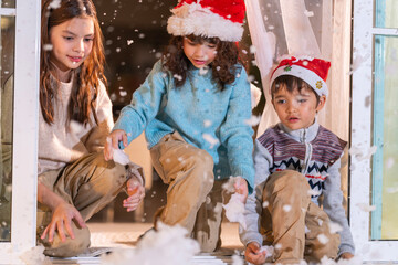 Smiling girl hugs a soft teddy bear gift beside the Christmas tree during a joyful family holiday celebration.