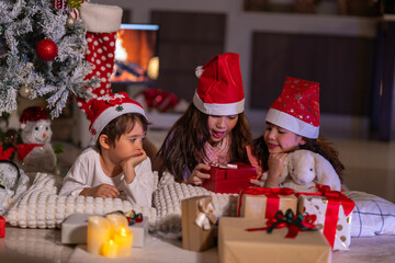 Happy children play with soft fake snow by a window during a festive Christmas morning celebration indoors at home together.