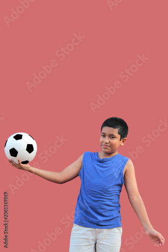 12-year-old Latino boy with dark skin plays with his soccer ball to practice for the game 