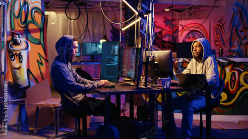 Fotografie Hackers developing zero day exploit undetectable by antivirus software installed on systems in order to steal valuable data from users, rogue programmers in hideaway look for ways to trick firewalls