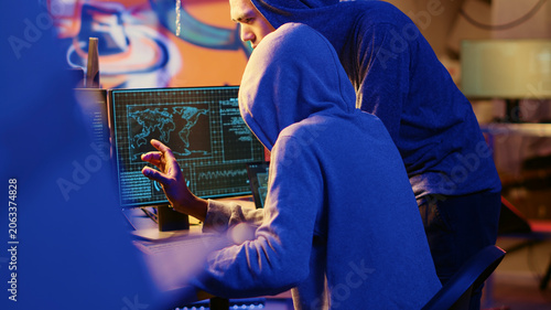 Slika na platnu Hacking group founder initiating new member, showing him how to destroy firewalls and infect victim computer in hideout, evil cybersecurity guru teaches script kiddie how to write malware code