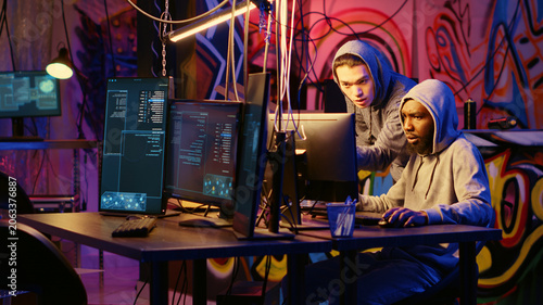 Slika na platnu Beginner hacker requesting help from experienced cybercriminal, learning how to destroy firewalls and infect victim computer, cracker in secret hideout teaches script kiddie how to write malware code