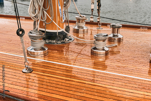 Karlskrona, Sweden - 16 September 2025: View of the polished wooden deck of a vintage racing yacht with chrome winches and rigging in Karlskrona harbour.