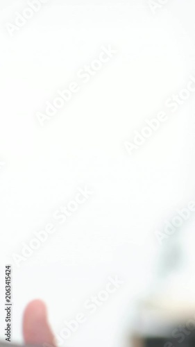 Vertical video: Camera shifting, right hand pulling dark-case phone from white frame, leaving blank