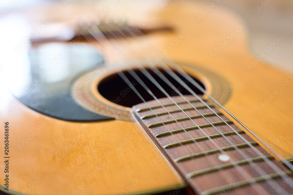 Obraz premium Close up of acoustic folk guitar strings and soundhole with wooden body