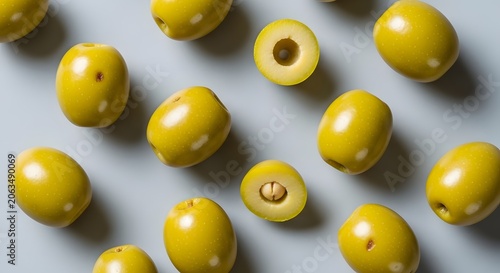 Fresh green olives scattered on a light gray surface from above