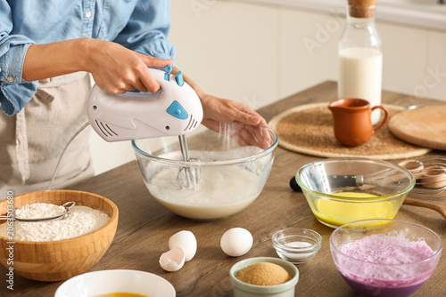 Young woman using mixer at ...