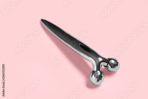Face massage roller on pink...