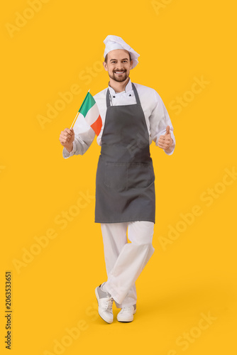 Male chef with flag of Italy showing thumb-up on yellow background