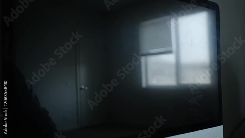 Reflection of a Bright Window and Interior Door on a Dark Glossy Computer Monitor Screen in a Dimly Lit Room.