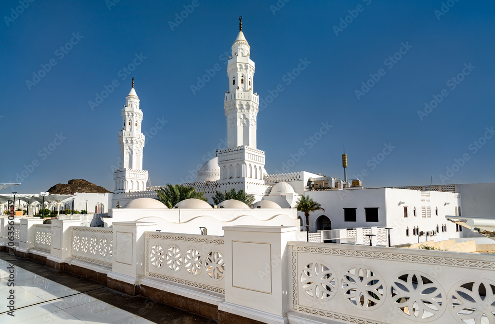Obraz premium The white facade and minarets of Masjid al-Qiblatayn under a clear blue sky in Medina, Saudi Arabia