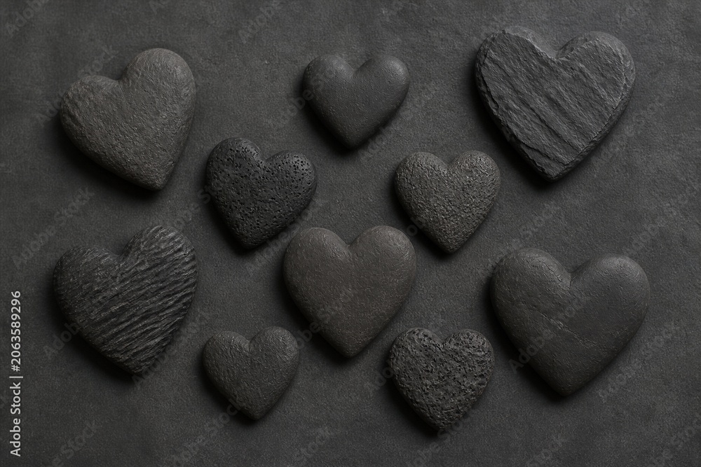 Obraz premium Stone heart shapes arranged on dark textured surface