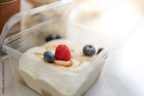 Fotografija fresh berry cream dessert served in clear transparent box