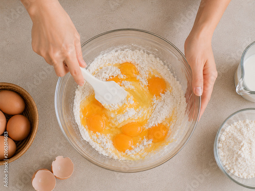 Top-Down View of Mixing Flour and Egg Yolks in a Glass Bowl