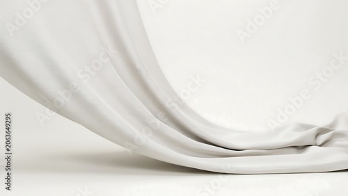 A white cloth draped elegantly on a plain white surface with soft folds