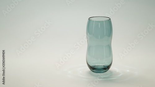 Elegant blue glass vase on white surface with reflections