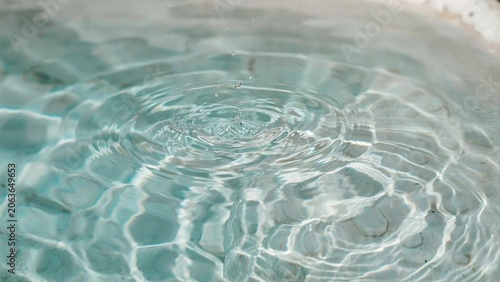 Closeup of clear water surface with ripples and droplets