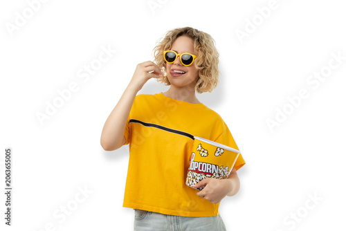 Woman holds popcorn and smiles in a casual outfit, PNG
