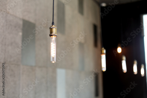 A filament light bulb with an orange light is suspended from the ceiling.