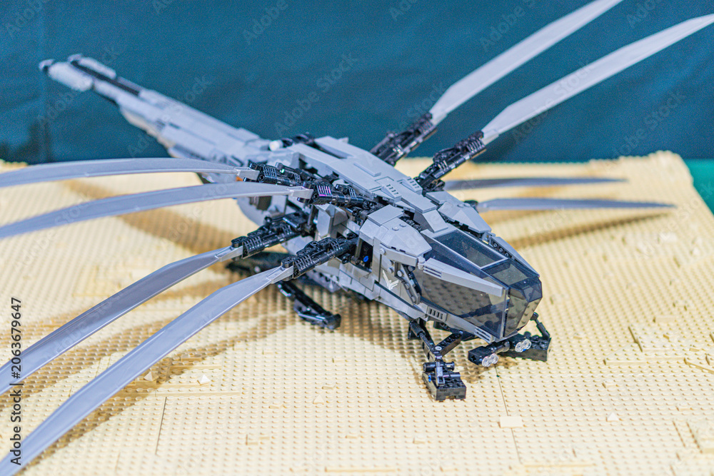 Naklejka premium Lego model of a dragon on Lego platform, dark gray and black dragon with light gray wings, beige platform, out of focus background, detailed craftsmanship - Kyiv, Ukraine - June 7, 2025