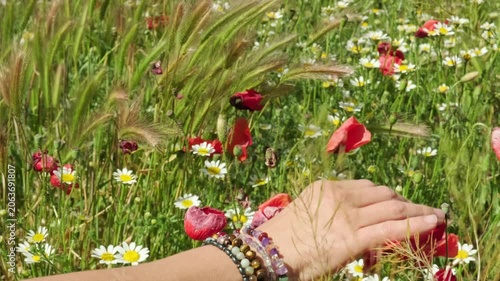 Woman wearing energy healing bracelets feeling the energy of nature in a field of flowers.