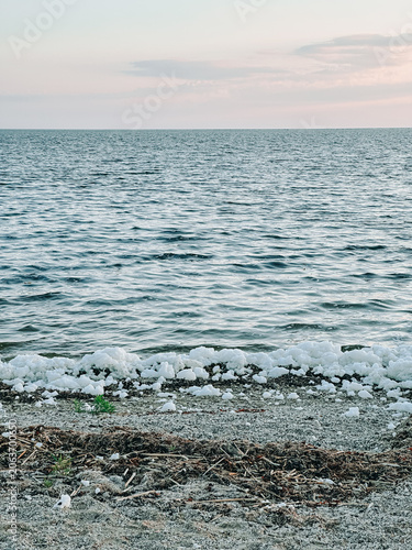 Salt Crystals on Shoreline of Calm Lake at Sunset