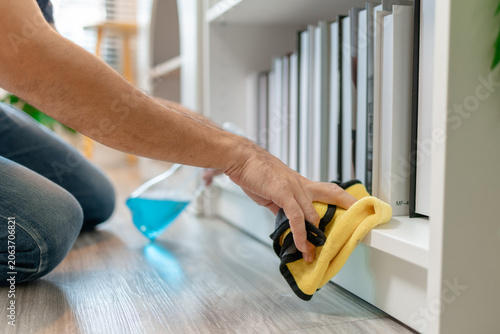 Obraz na plátně Professional home and office cleaning with disinfecting spray, wiping shelves, dusting furniture and sanitizing sofa surfaces to maintain a clean, organized and healthy indoor environment