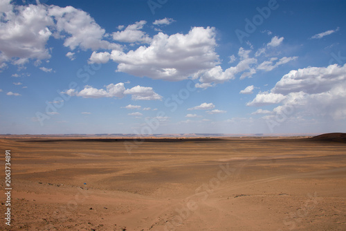Fotografija A dirt and gravel track leads towards the fine sand hills of the Merzouga Desert in Morocco