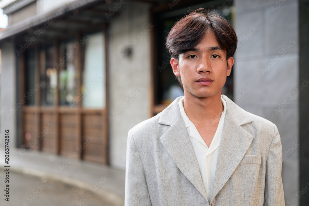 Obraz premium Portrait of non-binary Thai Isan professional standing on street
