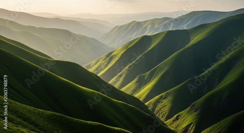 Sunlight illuminating lush green mountain valleys at dawn