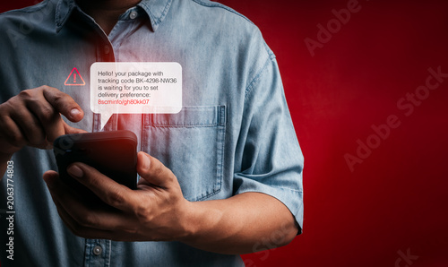 Obraz na plátně Person receiving fake delivery SMS with phishing tracking link on smartphone