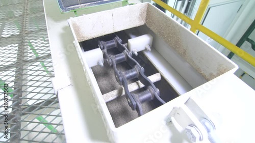 Working scraper chain grain feed conveyor in industrial workshop manufactory.