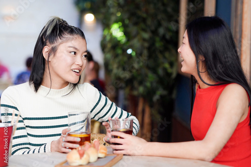 Women share startup thoughts. Friends discuss innovative business concepts at cafe outside