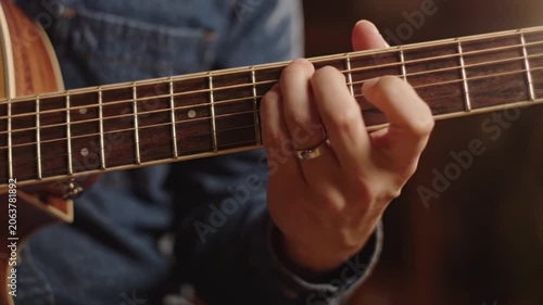 A Close-Up of Guitar Playing: Capturing the Art of Musical Expression with Hands Skillfully Navigating the Strings in an Intimate Setting