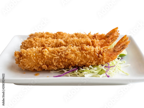 Crispy golden fried tempura shrimp served on a white square plate with shredded cabbage and lime wedges to create a delicious japanese style appetizer that looks extremely appetizing and fresh for hun
