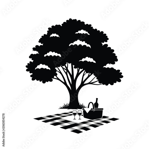 Picnic under a large tree with wine and glasses.