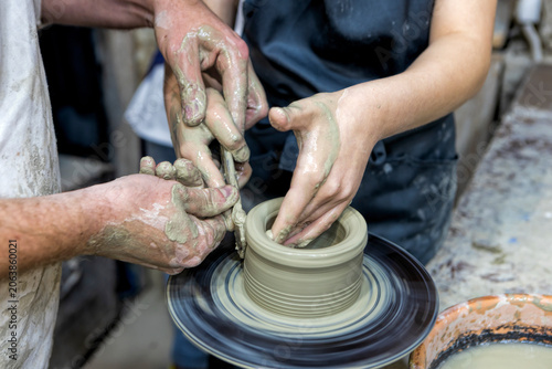 Foto Pottery art class with teacher helping student create ceramic pot
