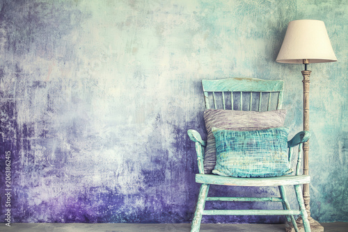 Calm quiet vintage interior room with an old chair and lamp. rustic textured wall background offers copy space