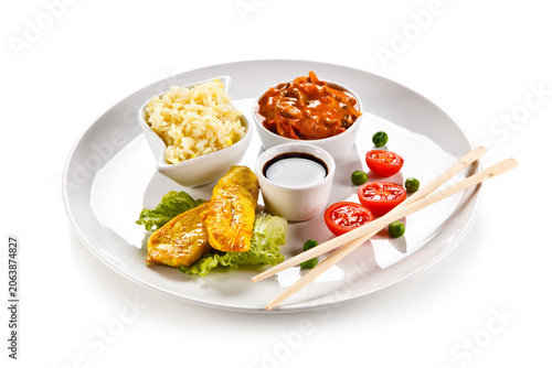 Fried chicken nuggets, white rice and vegetables on white background
