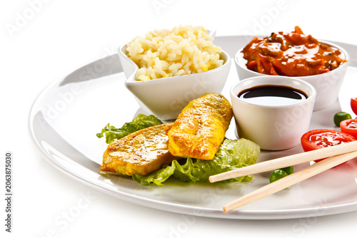 Fried chicken nuggets, white rice and vegetables on white background
