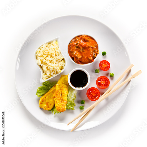 Fried chicken nuggets, white rice and vegetables on white background

