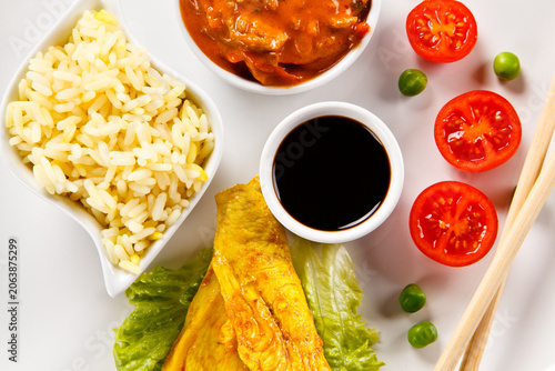 Fried chicken nuggets, white rice and vegetables on white background
