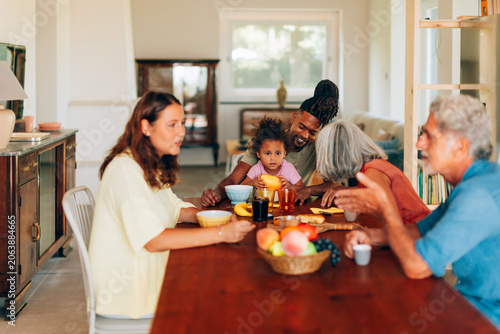 Multigenerational family enjoying breakfast conversation at home