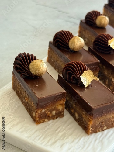 Luxury Chocolate Hazelnut Mignon Cakes with Edible Gold Leaf on White Plate