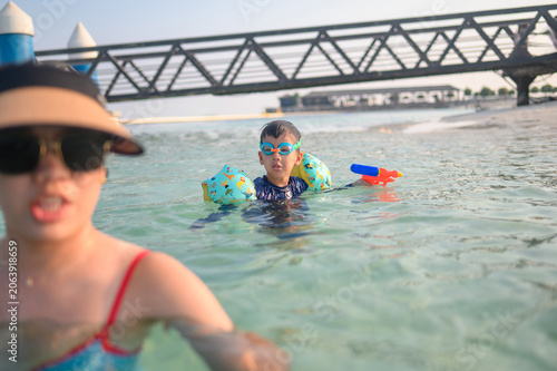 Playful Child Swimming in Shallow Water with Inflatable Arm Floaties