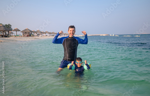 Joyful Father and Son Celebrating Together in Shallow Tropical W