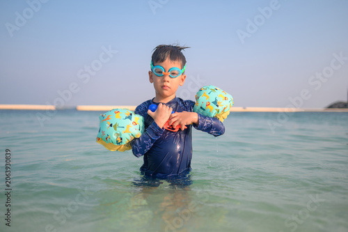 4-Year-Old Multiracial Boy in Swim Gear Playing in Clear Water