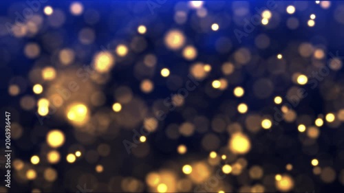 Blue and gold bokeh particles float across a dark background, creating an elegant abstract atmosphere with cinematic depth and soft glow.