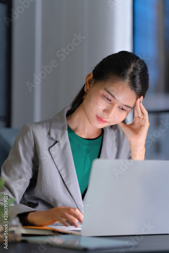 Cuadro en lienzo tired asian businesswoman stressful at workplace, late night